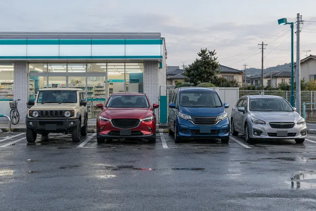 Марки японских машин: Suzuki Jimny, Mazda CX-3, Honda Freed и Subaru Impreza на парковке в японском пригороде