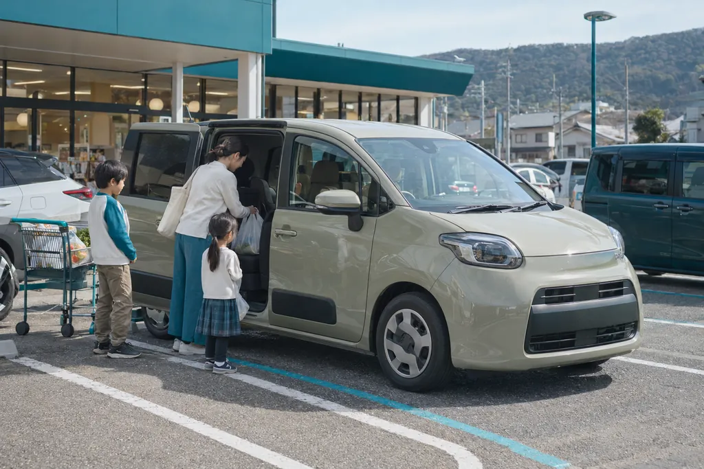 Toyota Sienta: женщина ставит покупки в компактный минивэн цвета хаки на парковке супермаркета